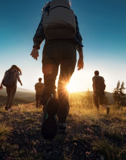 hikers on mountain heading into a setting sun<br />
